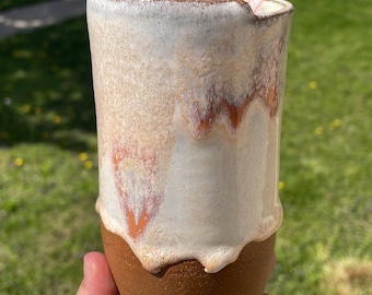 Tazza da viaggio in ceramica fatta a mano con smalto colato bianco, arancione e rosa.