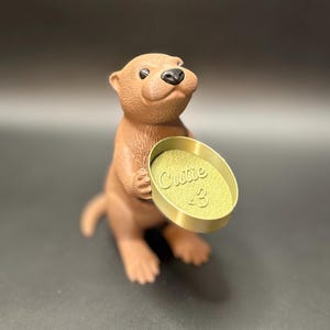 Bronze dish

A cute otter-shaped jewelry holder with a trinket dish, available in multiple colors for added charm.
