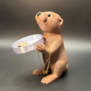 A cute otter-shaped jewelry holder with a trinket dish, available in multiple colors for added charm.