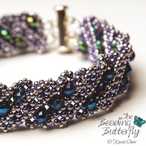 Puede incluir: Una pulsera de cuentas adornada en tonos morados, dorados y azul iridiscente. La pulsera está hecha con pequeñas cuentas y gemas facetadas más grandes. El texto "Fold Me Up" está en la esquina superior izquierda. Mide unos 19 cm de largo.