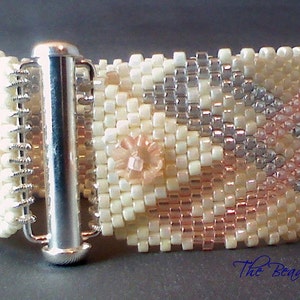 May include: A beaded cuff bracelet with a geometric pattern in cream, silver, and rose colors. The bracelet features a silver clasp and a small floral accent. The text "The Beading Butterfly" is visible in the lower right corner.