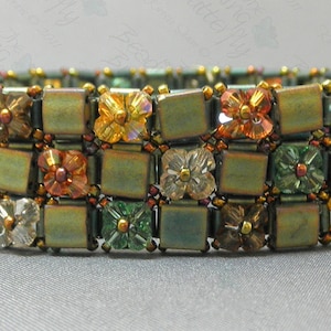 May include: A multi-layered bracelet with a checkered pattern of green, brown, and gold square beads. The bracelet is adorned with small flower-shaped beads in shades of orange, white, and green.