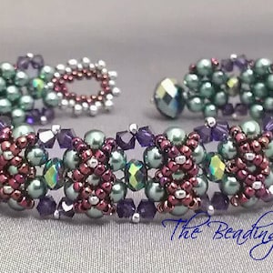 Puede incluir: Un brazalete de cuentas con un diseño multicolor. El brazalete está hecho con cuentas verdes, moradas y rojas. El brazalete es un diseño tejido con un patrón repetitivo.
