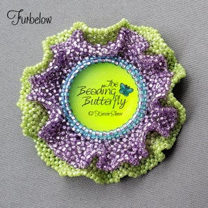 May include: A green and purple beaded flower with a round, green, and blue frame. The frame has a butterfly graphic and the text "The Beading Butterfly © Kassie Shaw".