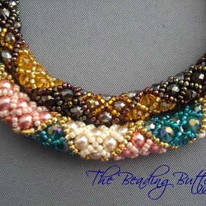 May include: Close-up of a multi-colored beaded necklace with a twisted design. The necklace is made with pink, white, gold, brown, and teal beads.