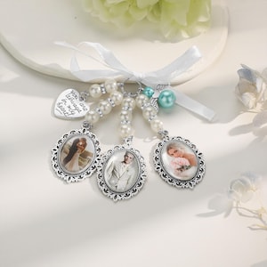 May include: A white pearl and ribbon keychain with three silver photo frames. The frames contain photos of a couple. The keychain also has a small silver heart charm with the text "You are always in my heart".