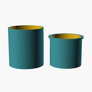 Pode incluir: Dois recipientes cilíndricos de alturas variadas, ambos com um exterior em tom verde-azulado profundo e um interior amarelo brilhante contrastante. O recipiente mais alto está à esquerda, enquanto o mais curto e largo está à direita.
