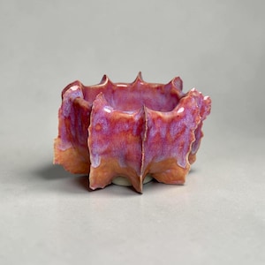 May include: A set of three ceramic nesting bowls in graduating sizes. The bowls are white with a speckled, textured finish and feature a slightly flared rim. Ideal for food prep or serving.