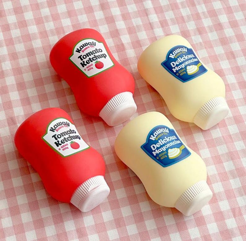 May include: Four novelty squeeze bottles, two red and two yellow, resembling ketchup and mayonnaise. The red bottles have a label that reads "Kawaii Tomato Ketchup". The yellow bottles have a label that reads "Kawaii Delicious Mayonnaise". Each bottle is approximately 400g.