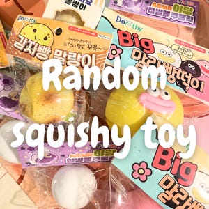 Puede incluir: Una colección de juguetes blandos de colores, incluyendo un pato amarillo con detalles rosas y un juguete con forma de patata. La imagen presenta embalajes con texto coreano y las palabras "Random squishy toy" en blanco.