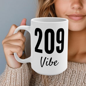 May include: White ceramic mug with a black design that says "209 Vibe".
