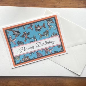 Tarjeta de cumpleaños con un pez caprichoso en tela azul con borde naranja: perfecta para los amantes de los peces y para celebraciones divertidas