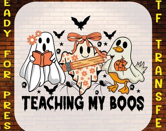 May include: A DTF (Direct to Film) transfer design featuring three cartoon ghosts. One ghost reads a book, another holds a pencil, and the third carries a pumpkin. The phrase "TEACHING MY BOOS" is printed below the ghosts, with bats and spiders.