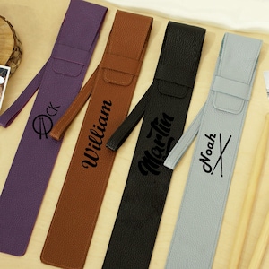 Puede incluir: Cuatro estuches personalizados para baquetas en morado, marrón, negro y gris. Cada estuche tiene un nombre impreso: "Ock", "William", "Martin" y "Noah". También se ven dos baquetas y partituras.