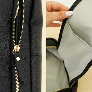 May include: A black backpack with a textured, pebbled surface and a gold-toned metal zipper. The interior is lined with a light gray fabric and features an open slip pocket. The exterior zipper pull is made of matching black material.