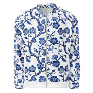 May include: A white bomber jacket with a blue and white floral pattern. The jacket has a zipper closure and a ribbed collar, cuffs, and hem.