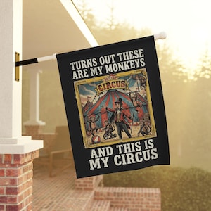 Peut inclure: Drapeau noir avec le texte "TURNS OUT THESE ARE MY MONKEYS AND THIS IS MY CIRCUS." Le drapeau présente une illustration de cirque vintage avec des singes, un maître de cérémonie et un chapiteau.