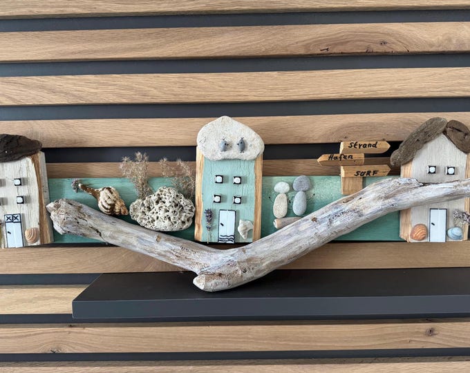 Maritime cottages, houses, and wooden houses decorated with driftwood from the North Sea and beach finds from the Baltic Sea. Small stone picture made from beach finds.