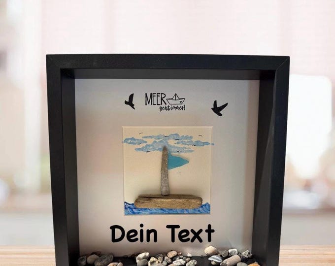 Maritime stone picture saying: The sea always goes with a North Sea sailboat made of driftwood and Baltic Sea beach finds.