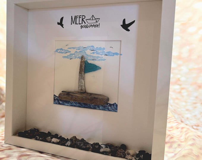 Maritime stone picture saying: The sea always goes with a North Sea sailboat made of driftwood and Baltic Sea beach finds.