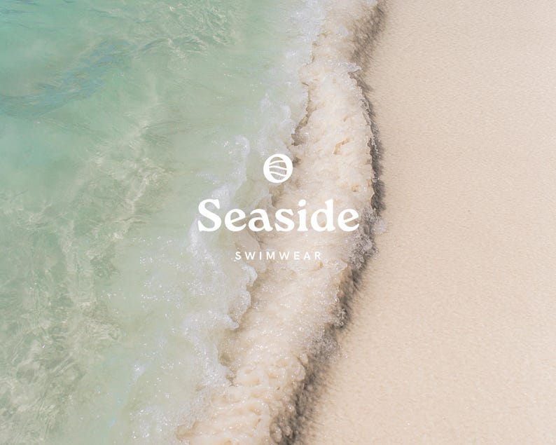 May include: A close-up of a wave breaking on a sandy beach. The water is clear and turquoise, and the sand is white. The text "Seaside Swimwear" is superimposed on the image.