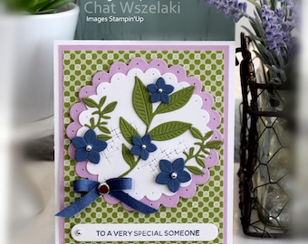 May include: A rectangular greeting card featuring a green and white polka dot background, a scalloped lavender circle, and a white die-cut circle with embossed cross-hatching. It includes blue flowers, green leaves, a blue ribbon, and the text TO A VERY SPECIAL SOMEONE.