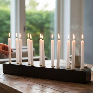 Długi drewniany świecznik, antyczne złote kubki, minimalistyczny element centralny