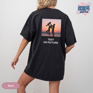 a woman wearing a black t - shirt with a picture of two people on it