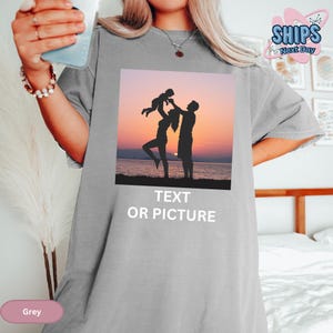 a woman holding a cup of coffee while standing next to a bed