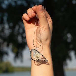 Pastel stained glass necklace shaped like a bird with floral accents.
