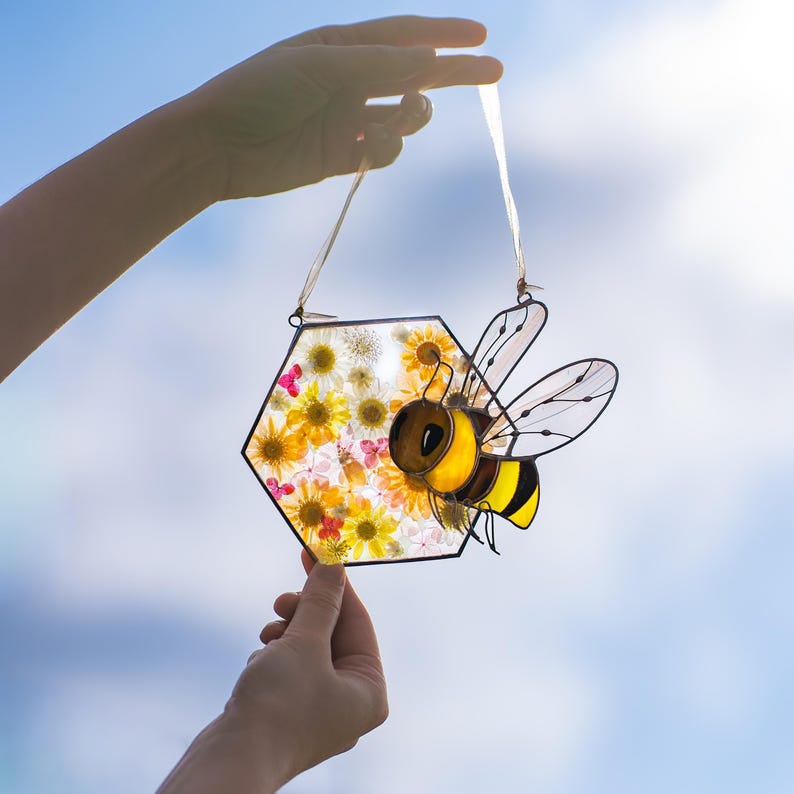 bee suncatcher with dried flowers displayed on picnic fabric outdoors