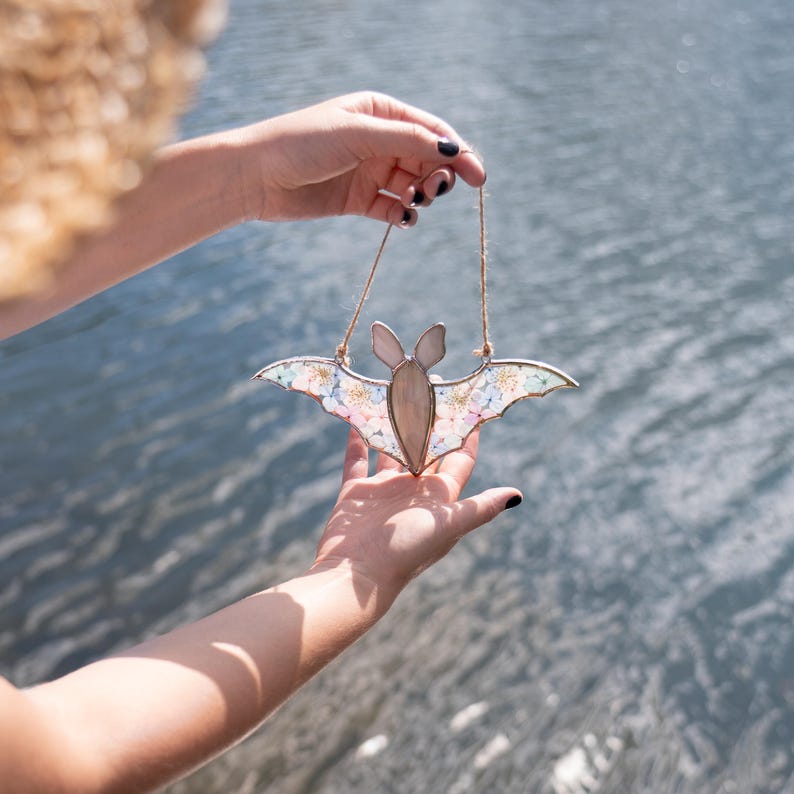 Handmade Halloween bat suncatcher glowing in sunlight