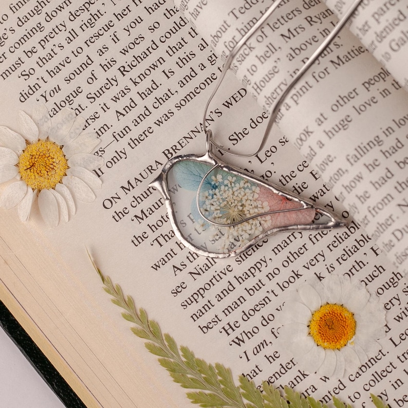 Handmade bird-shaped pendant featuring real pressed flowers.