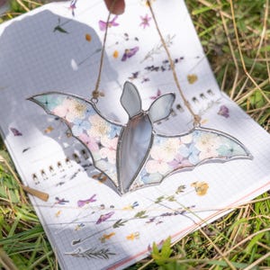 Dried flower-filled bat wings adding pastel charm to Halloween