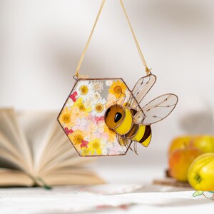 botanical glass bee ornament with yellow and white floral details