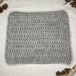 May include: A grey crocheted blanket with a soft, textured surface.
