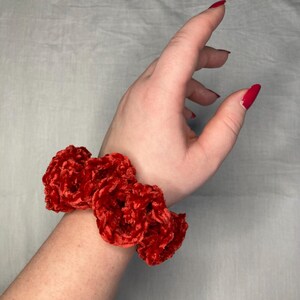 Può includere: Scrunchie in velluto rosso con una texture soffice. Lo scrunchie è realizzato in tessuto morbido e peluche ed è perfetto per aggiungere un tocco di stile a qualsiasi acconciatura.