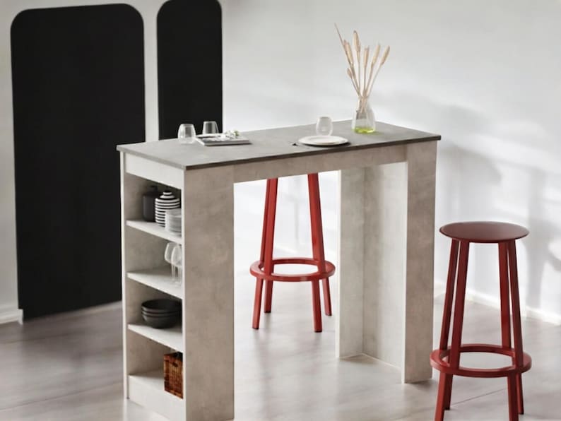 May include: A modern kitchen island with a gray countertop and built-in shelving. Two red bar stools are positioned near the island. The island has a built-in shelf with dishes and glassware. A vase with dried plants sits on the countertop.
