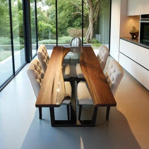 Könnte beinhalten: Ein moderner Esstisch mit einer Tischplatte aus rohem Holz und einem Glaseinsatz. Der Tisch wird von schwarzen Metallbeinen getragen. Sechs gepolsterte Stühle umgeben den Tisch. Der Raum hat große Fenster.