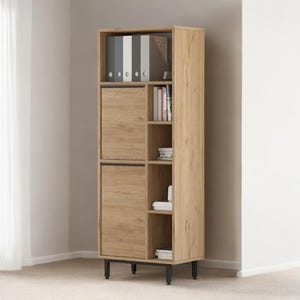 Op de afbeelding: Een hoge, lichtbruine houten kast met zwarte poten. De kast heeft twee deuren, open schappen en een bovenste gedeelte voor opslag. De kast is gevuld met boeken, ordners en decoratieve items.