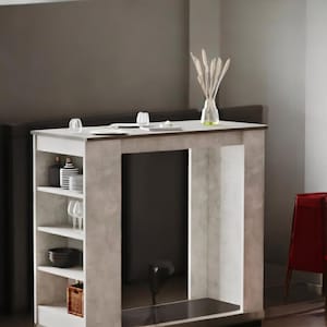 May include: A modern, light gray and white kitchen island with open shelving. The island has a dark countertop and a built-in shelf for storage. A red chair is next to the island. A vase with decorative stems sits on the countertop.