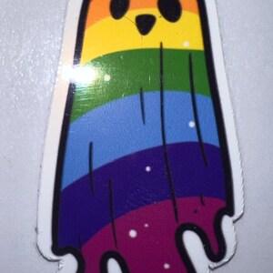 K&ouml;nnte beinhalten: Ein farbenfroher Aufkleber mit einem Cartoon-Geist in Regenbogenfarben. Der Geist hat ein schwarzes Gesicht mit zwei Augen und einem kleinen Mund. Die Regenbogenfarben umfassen Rot, Orange, Gelb, Gr&uuml;n, Blau, Lila und Rosa. Der Geist hat einen wei&szlig;en Rand.
