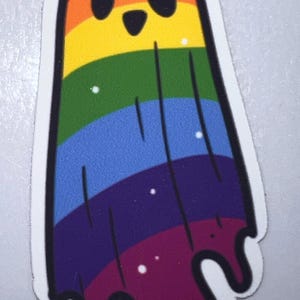 K&ouml;nnte beinhalten: Ein farbenfroher Aufkleber mit einem Cartoon-Geist in Regenbogenfarben. Der Geist hat einen wei&szlig;en Umriss und ein l&auml;chelndes Gesicht mit schwarzen Augen. Die Regenbogenfarben umfassen Rot, Orange, Gelb, Gr&uuml;n, Blau, Lila und einen dunkelvioletten Tropfeffekt am unteren Rand.