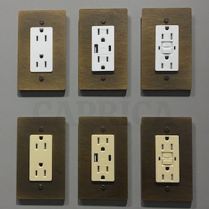 May include: Six electrical outlet covers with brass-colored wooden frames. The outlets are white or cream-colored, with standard and USB port configurations. Each cover is secured with two screws, showcasing a blend of functionality and design.