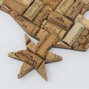 May include: A close-up of a cork star made from wine corks. The corks are arranged in a star shape and have various labels and text, including "PREDATOR", "NOBLE VINES", "DONOVAN-PARKE", "FERRARI-CARINO", and "CALLAWAY".