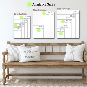 Puede incluir: Un banco de madera con dos cojines decorativos y una planta verde. Encima del banco hay tres impresiones enmarcadas en blanco que muestran los tama&ntilde;os disponibles, incluyendo 28x36 cm, 46x61 cm y 61x76 cm. Un coj&iacute;n tiene el texto "welcome home".