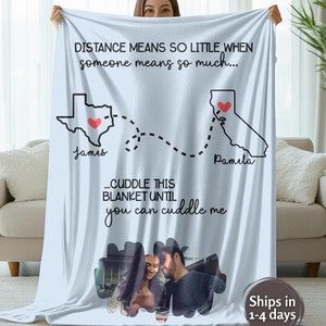 May include: A light blue fleece blanket with a map of the United States showing Texas and California. The states are connected by a dotted line. The text "DISTANCE MEANS SO LITTLE WHEN someone means so much..." is printed on the blanket. The text "...CUDDLE THIS BLANKET UNTIL you can cuddle me" is printed below the map. A photo of a couple is in the lower right corner of the blanket.