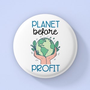 May include: White button with a green and blue illustration of a hand holding the Earth with the text "PLANET before PROFIT" in blue.