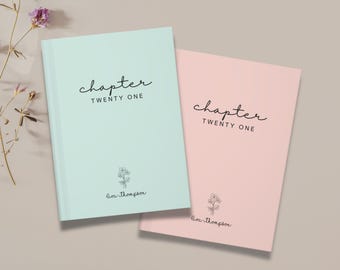 May include: Two hardcover journals, one mint green and one pink, are displayed. The cover of each journal features the word "chapter" in a handwritten font, followed by "TWENTY ONE". A small floral illustration and a name are below the text.