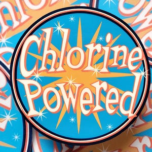 May include: A round sticker with the words "Chlorine Powered" in a retro font. The text is in white with a black outline, set against a blue background with an orange burst design. The sticker has a black and red border.